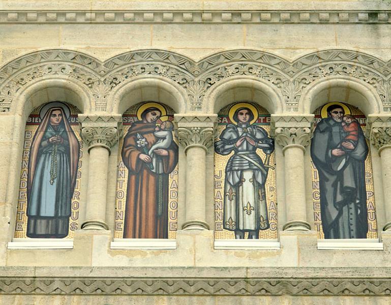 Façade occidentale : détail de quatre saints peints par l'atelier bordelais G.P. Dagrant ; de gauche à droite figurent sainte Bernadette Soubirou, saint Antoine de Padoue, Jeanne d'Arc et saint Vincent de Paul.