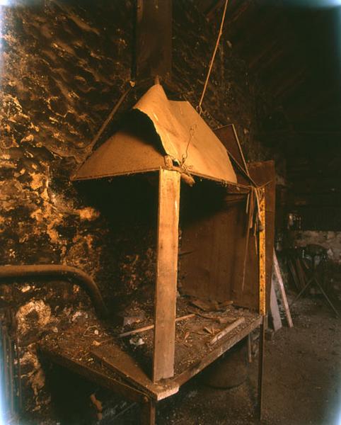 le foyer de la forge surmonté de sa hotte