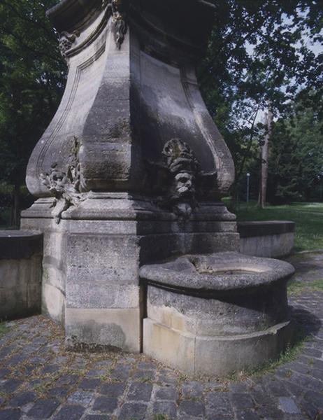 Fontaine en borne illustrant la gloire du roi Louis XV, autrefois sur le pont des Belles fontaines côté amont, replacée dans le parc du château de la Cour de France : vasque et mascarons.
