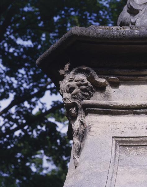 Fontaine en borne illustrant la gloire du roi Louis XV, autrefois sur le pont des Belles fontaines côté amont, replacée dans le parc du château de la Cour de France : tête de bélier supportant la corniche qui couronne le piédestal du groupe sculpté..
