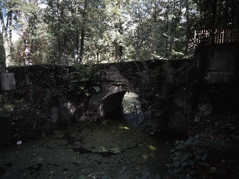 Pont en pierre franchissant la rivière artificielle dans l'axe du château.