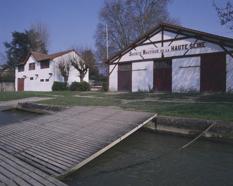 Vue d'ensemble des deux bâtiments de la base nautique vus depuis le ponton flottant sur la Seine.