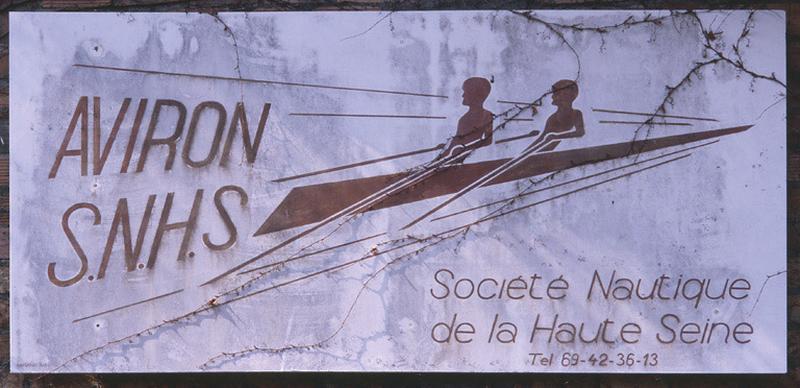 Affiche-enseigne de la SNHS aujourd'hui encadrée sous verre dans le club-house.