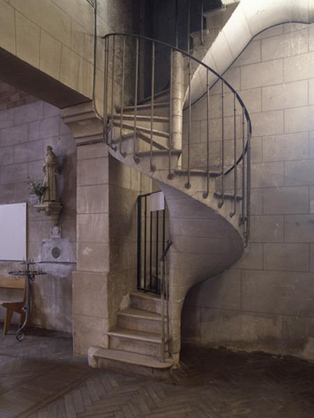 Escalier donnant accès à la tribune situé à droite de la porte d'entrée.