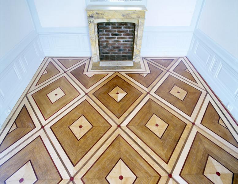 Boudoir situé dans le prolongement d'un petit salon faisant suite au grand salon, à l'angle du corps de bâtiment principal, côté parc : détail du parquet en marquetterie et de la cheminée.