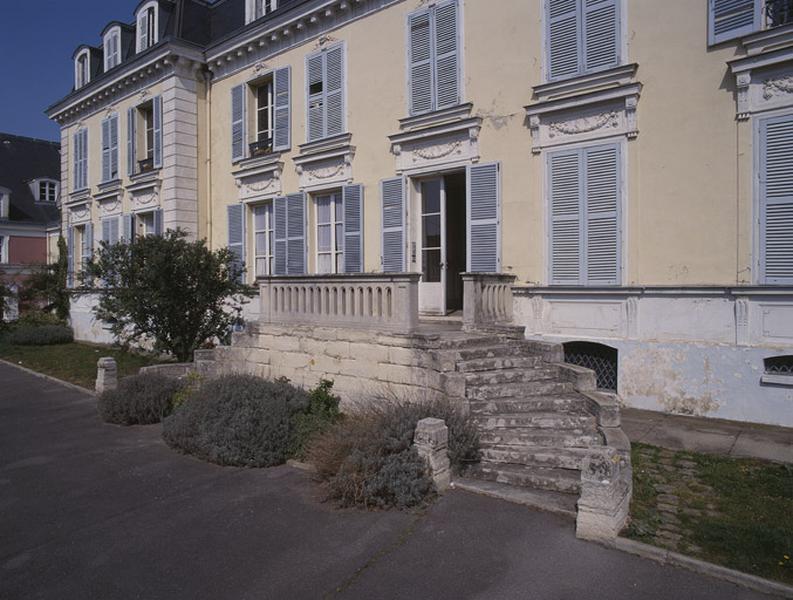 Escalier en fer à cheval situé devant la façade principale.