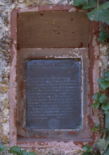 Plaque commémorative de la pose de la première pierre pour la réédification de l'église de Notre-Dame de la Consolation le 22 mai 1739. Cette plaque est scellée dans le mur de la maison, près de la porte d'entrée.