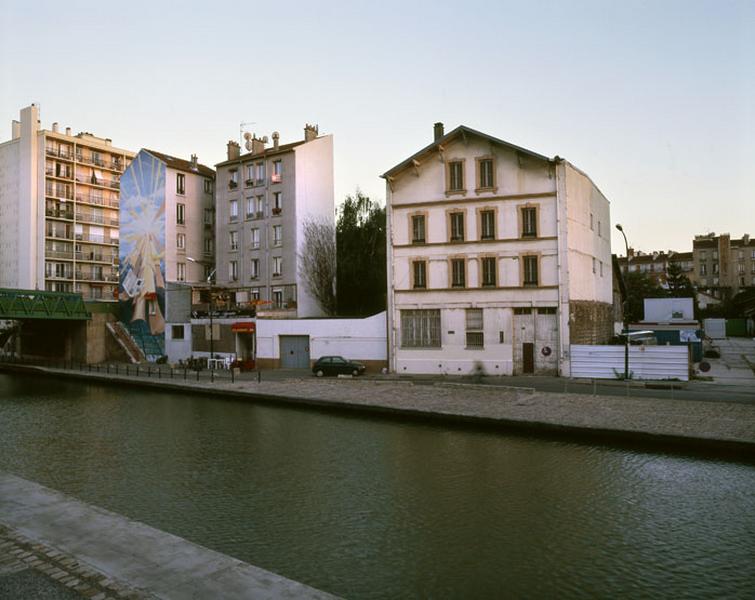 Vue de l'entrepôt industriel depuis la rive droite du Canal de l'Ourcq.