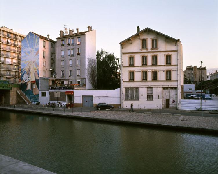Vue de l'entrepôt industriel depuis la rive droite du Canal de l'Ourcq.