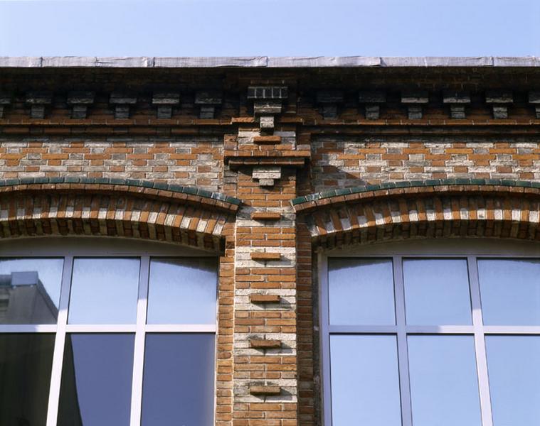 Détail du décor d'un trumeau et de deux linteaux en plein-cintre de la façade sur rue du bâtiment administratif depuis la rue Victor Hugo.