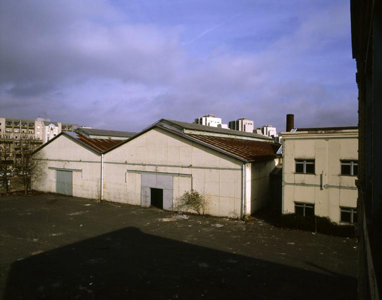 Vue des entrepôts à toiture à longs pans situés le long du quai de l'Aisne depuis le 1er étage du bâtiment administratif.
