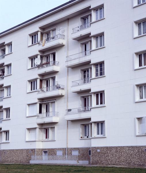 Détail d'une façade comprenant balcons et fenêtres d'angle dans des redants.