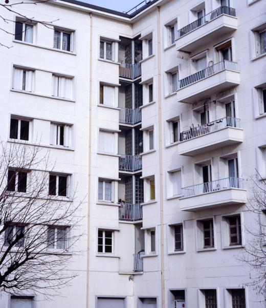 Détail de l'angle rentrant de deux bâtiments perpendiculaires présentant une mise en oeuvre soignée des ouvertures.