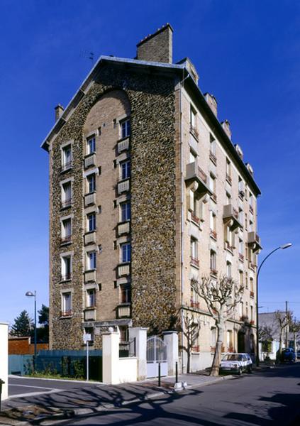 Vue d'ensemble et l'immeuble à l'angle de ses deux façades largement percées.