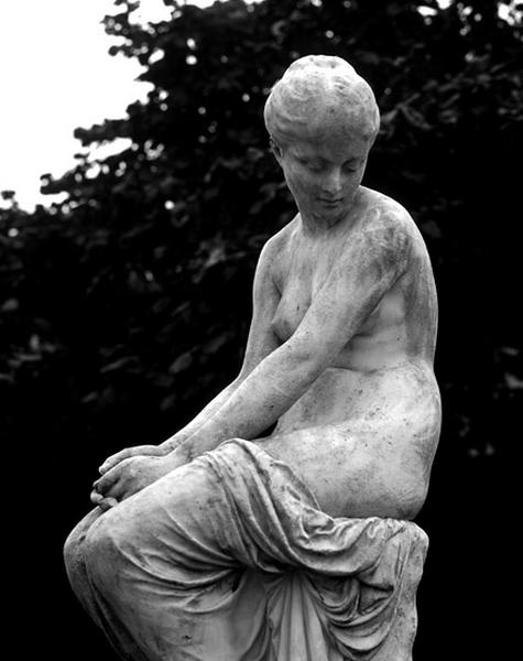 Détail de la sculpture représentant une nymphe, assise, se penchant sur deux hirondelles. Le groupe est placé dans la cour du Centre technique du bâtiment.