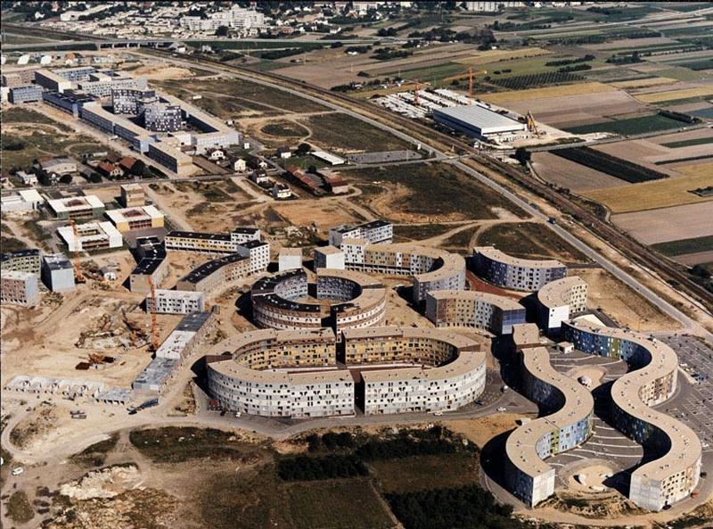 Vue aérienne de la ZAC durant le chantier. A gauche de l'image, la place de l'Eté Vert n'est pas complètement sortie de terre. Au fond à droite, au delà du chemin de fer, l'usine de préfabrication des panneaux de façade de l'entreprise Pascal. A l'extrème droite de l'image, la gare n'est pas encore réalisée. Au centre, les places du Pas et des Pierreuses ne sont pas commencées.