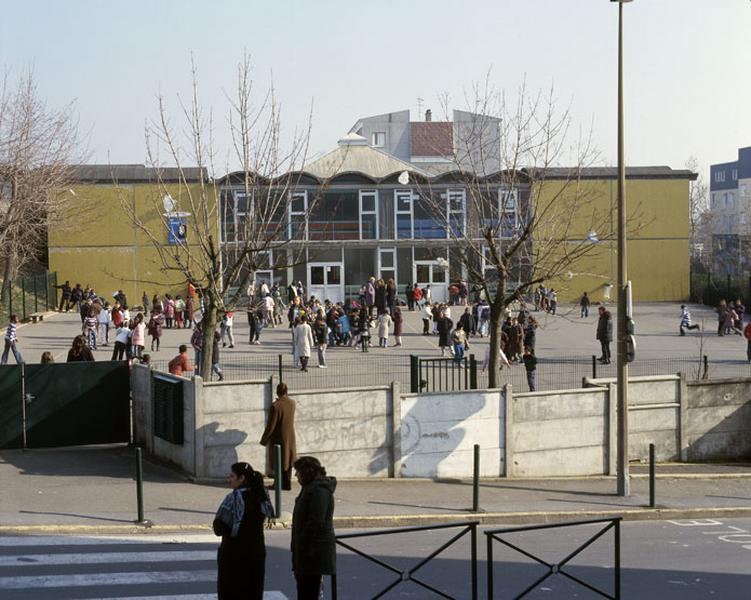 Vue d'un des bâtiments donnant sur une cour de récréation.