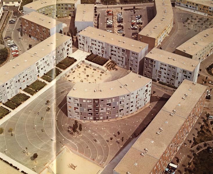Vue aérienne de la place de l'Eté-Vert, en haut de l'image la place de l'Ysé, en haut à droite, la place du Trident. On distingue les jardins privatifs associés à certains logements en rez-de-chaussée, ainsi que le traitement du sol (rubans de béton formant des degrés en suivant les courbes de niveau)