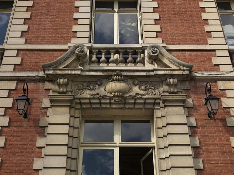Vue du linteau de la porte et du garde-corps à balustres de la fenêtre du 1er étage.