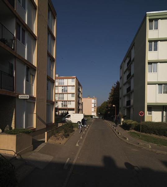 Ensemble de bâtiments 'pavés' ou plots le long de la rue Paul-Verlaine.