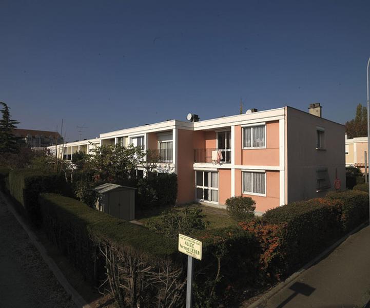 Logements individuels en bande, précédés de jardinets privatifs clos de haies, le long de l'allée Fernand-Léger.