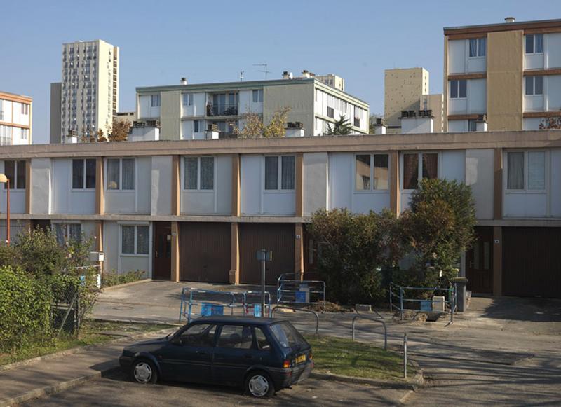 Immeubles de différentes hauteurs ; au premier plan, individuels en bande, avec garages intégrés, de l'allée Jean-Mermoz.