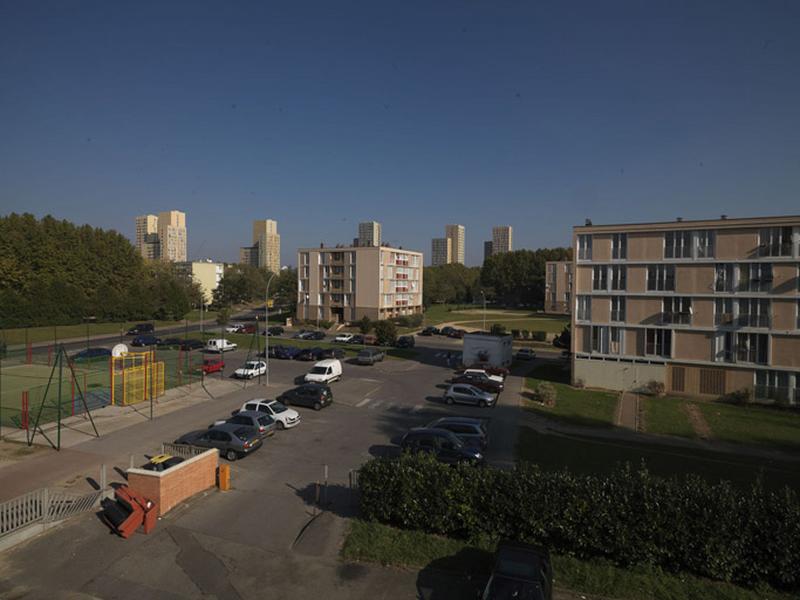 Vue de la place herborée située à l'angle des rues Saint-Just et Joliot-Curie, prise de l'ancien immeuble de logements de l'école Joliot-Curie.