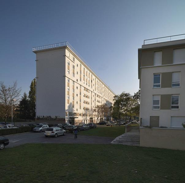Vue de l'immeuble implanté en bordure de la rue des Edelweiss (n° 4-12) ; le rez-de-chaussée est occupé par des garages. A droite, départ de l'immeuble incurvé longeant la rue Pierre-Brossolette.