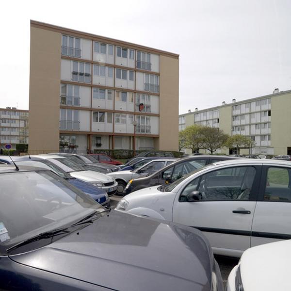 Voitures stationnées entre les immeubles.