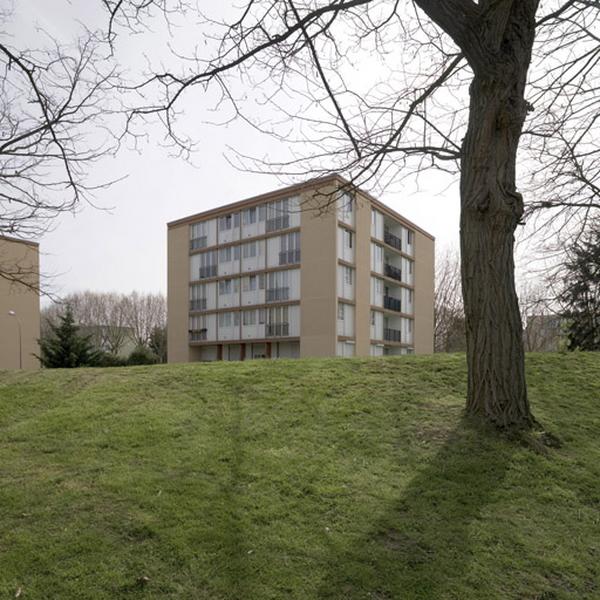 Un immeuble cubique de la place Ambroise-Paré vu de la pelouse descendant vers l'avenue Frédéric-Joliot-Curie.