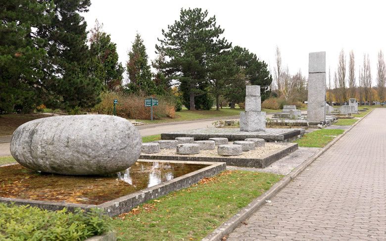 Vue actuelle d'une partie de la sculpture. Au premier plan à gauche, « l'oeuf de la conception », puis les neuf plots du « lac de la connaissance » puis « les cubes de l'enfance », enfin, élément le plus haut, « la porte de la connaissance de soi ».