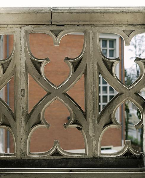 Façade d'entrée : vue du remplage aux motifs trilobés de l'une des baies du premier étage.