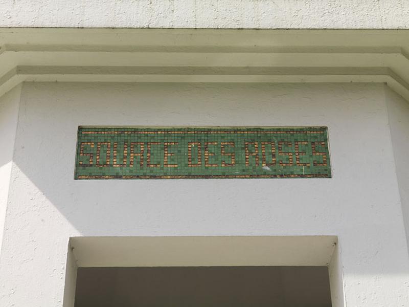 Détail des inscriptions portées dans des panneaux de mosaïque : 'source des roses'.