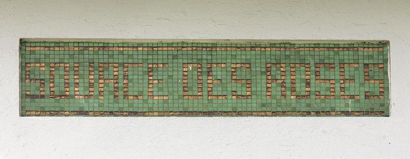 Détail des inscriptions portées dans des panneaux de mosaïque : 'source des roses'.