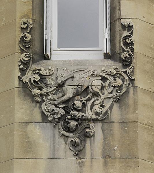 Détail sculpté de l'une des baies d'angle : décor de griffon.