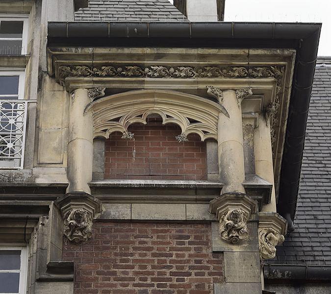 Façade sur le lac. Détail de la composition architecturale sur les parties hautes du pavillon central : motif d'arc, rehaussé de petites arcatures trilobées, encadré de colonnes supportées par des culots ornés de personnages. Le tout est couronné d'une frise de feuillages très découpés dans un style néogothique.