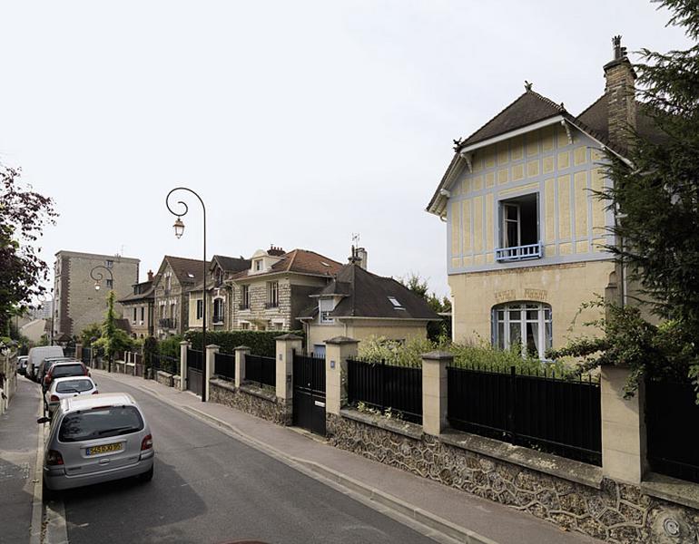 Vue d'ensemble de la maison et de son garage depuis la rue