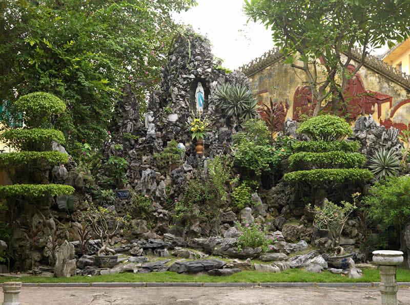 Vue d'une rocaille dans le jardin de la mission, rue Nha Chung. Elle mêle le thème vietnamien traditionnel de la montagne céleste et celui, chrétien et moderne, de la Vierge de Fatima.