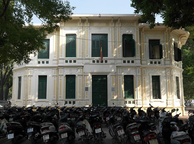 Ancien siège de l'AFIMA, angle rue Le Thai To et rue Hang Trong. Vue de la façade. Ce bâtiment représente une synthèse de l'architecture occidentale et vietnamienne. Le dessin d'ensemble reprend des éléments occidentaux : toit-terrasse sur corbeaux en béton, façade à travées régulières, grandes fenêtres, scandées de pilastres