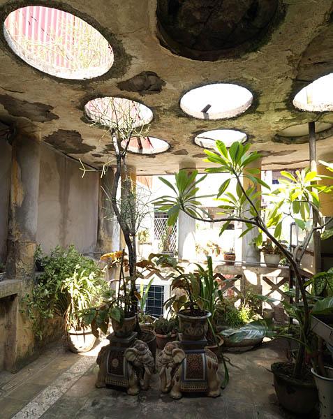 Villa, rue Dinh Liêt. Vue d'une terrasse, recouverte d'une toiture en béton, laissant passer la lumière par des ouvertures circulaires.