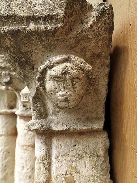 Détail du portail : tête d'homme, sculptée sur le chapiteau du piédroit nord.