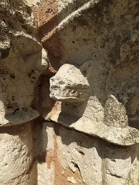 Détail du portail : tête de monstre, sculptée sur le chapiteau du piédroit nord.