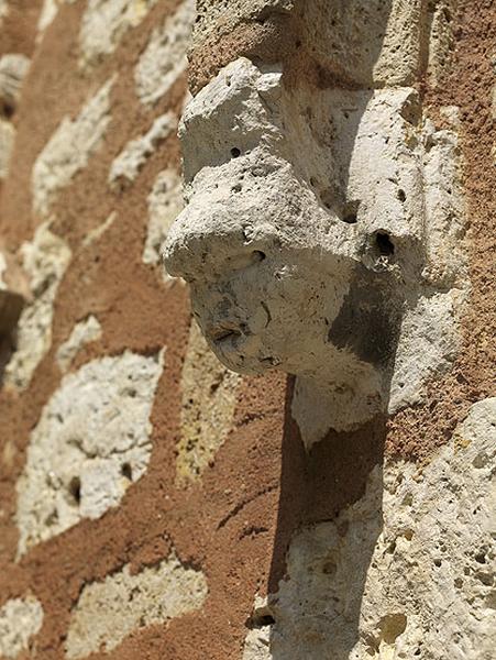 Détail du portail : corbeau sculpté en forme de tête, au départ de l'archivolte.