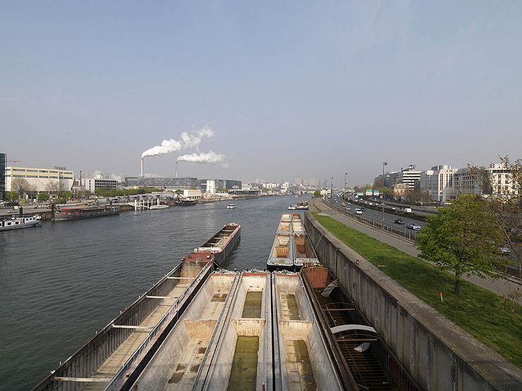 Ivry-sur-Seine. Vue depuis la Seine vers Paris. Au premier plan, des barges à quai à Charenton-le-Pont.