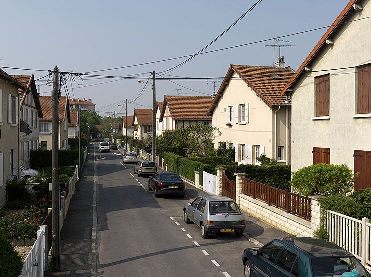 Vitry-sur-Seine, cité jardin dite cité du Moulin Vert, rue du Moulin Vert, rue de France, rue Camille Rich, rue Eugène Derrien, rue du Chat Botté, rue Peau d'Ane, rue Antoine Mimerel, rue des Contes de Fées, rue Georges Urbain, square Jean de la Fontaine, rue des Jardins. Perspective d'une rue de la cité jardin.