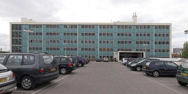 Vitry-sur-Seine, immeuble industriel Burosud, 40-62 rue du Général-Malleret-Joinville. Vue arrière du bâtiment de bureaux et des entrepôts en RDC qui servent de parking automobile.