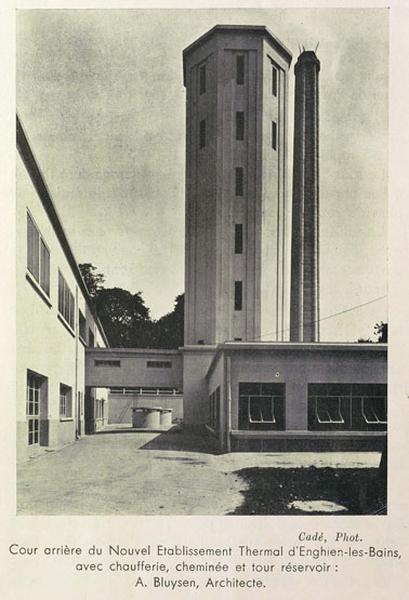 Vue sur la cour arrière ave la haute tour réservoir et les différents bâtiments de la chaufferie.