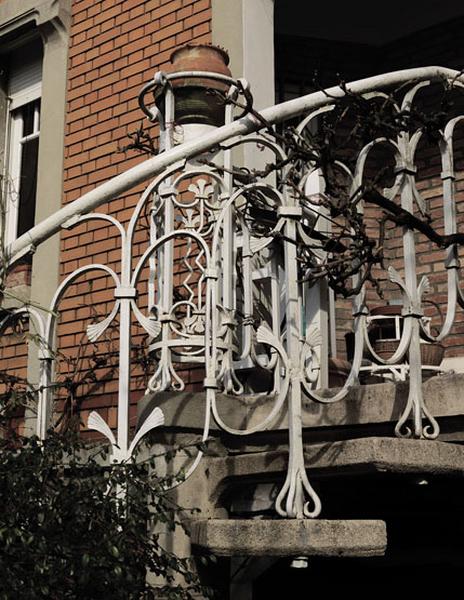 Détail de l'escalier, balustrade en ferronnerie, probablement dessinée par Emile Robert, ferronnier d'art. La balustrade est fixée par des rivets dans les marches en béton.
