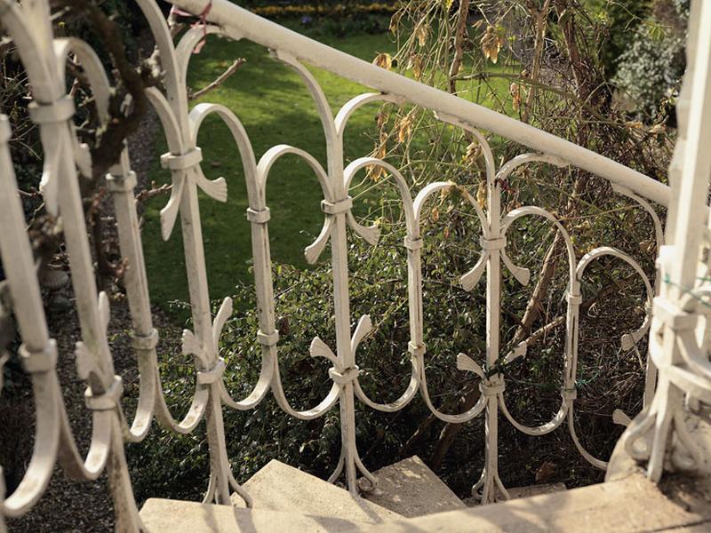 Détail de la balustre en ferronnerie de l'escalier extérieur conduisant du jardin au rez-de-chaussée surélevé, probablement dessiné par le ferronnier d'art Emile Robert.
