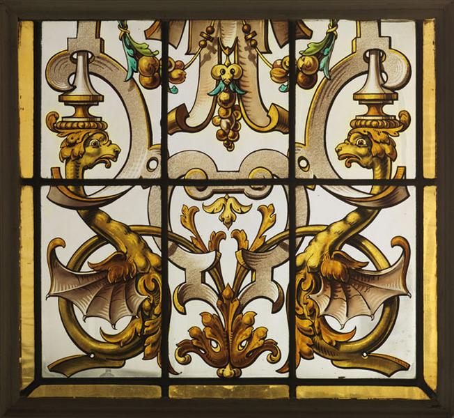 Verrière déposée du salon : détail du motif de la partie inférieure de l'un des panneaux centraux avec des dragons affrontés.